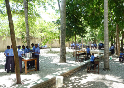 Les élèves prennent le repas de midi pendant qu'Haïti Futur installe le TNI dans l'école,.